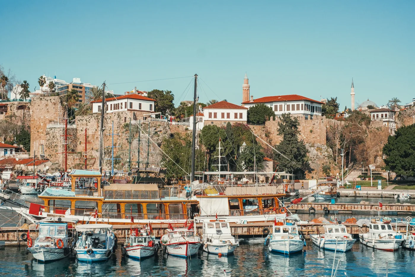 Oude haven van Antalya met vissersboten onder de stadsmuur van Kaleiçi